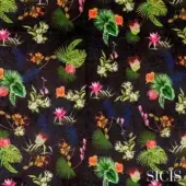 Sicis Jardin fabric with tropical foliage, dark background, green palm leaves, orange and pink flowers, blue stalks, textured surface.