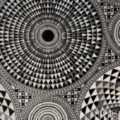 Black and white textile pattern, concentric triangles radiating from a solid black center, with checkerboard and geometric motifs visible.