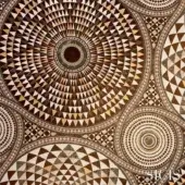 Numisma bronze fabric with concentric circles and geometric shapes in brown and beige, detailed mosaic texture, SICIS brand visible.