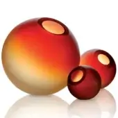 Spherical decor objects, clear & red glass, feature gradient yellow-to-red and solid red finishes with circular cutouts, reflecting on a white surface.
