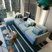 Elegant Giorgetti Moorea sectional with pewter stainless steel frame and muted blue-grey woven fabric upholstery accented with throw pillows