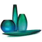 Glass vases and tray in teal and green, hammered texture, cylindrical, spherical, and rectangular forms, white background.