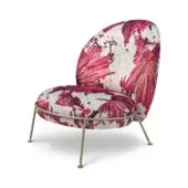 Armchair, rose mosaic upholstery, cocoon shape with brass legs; studio shot on white background.