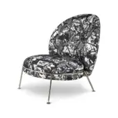 Accent chair, black and white fabric, rounded back with abstract dripping paint pattern and polished metal splayed legs.