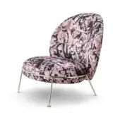 Accent chair, dripping rose fabric, rounded silhouette with brass legs, black, pink, and cream mosaic pattern, modern sculptural design.