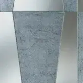 Decorative mirror with grey, textured glass tiles in irregular geometric shapes, featuring a mottled, aged finish and dark grey framing.