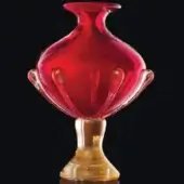 Glass vase, polished red and gold Cabembo, rounded bulbous shape with flared rim and curved tendrils on speckled metallic base.
