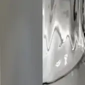 Reflective curved surface, metallic grey, undulating waves with circular highlights, smooth glossy finish, directional lighting, plain background.