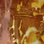Corroded metal texture displaying mottled brown, reddish-brown, yellow, and white oxidation with a central horizontal crack and rough, granular surface.