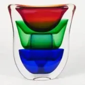 Glass vase with nested red, green, and blue glass forms, layered within a clear exterior, featuring a rounded, organic shape.