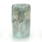 Glass vessel, turquoise with gray and amber spots, cylindrical shape with thick, swirled rim and hand-blown texture on white background.