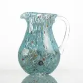 Turquoise glass pitcher with speckled design, rounded body, clear handle, mosaic-like pattern of red, orange, yellow, blue, and white dots.