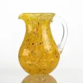 Yellow glass pitcher with speckled pattern, rounded body, curved handle, and translucent finish displayed on a white surface.