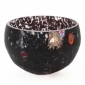 Glass bowl, black with white spotted pattern, featuring red, blue, gold inclusions and swirling interior lines, studio shot.