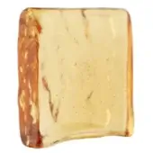 Amber block, translucent golden-brown, irregular shape with striated texture and undulating edges against a white backdrop.