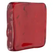 Ruby glass sculpture, molded red glass, uneven rectangular shape with glossy finish and internal bubbles.