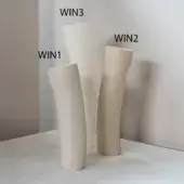 Ceramic vases, creamy white and beige, display conical, hourglass, and asymmetrical shapes against a light gray wall.
