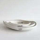 Ceramic bowl set, white matte finish, stacked arrangement featuring undulating rims and minimalist labels “LGUMI”, “LGUPI”, “LGU”.