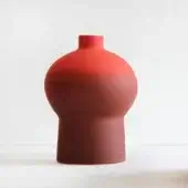 Terracotta vase, red-orange color, rounded cylindrical form with striated texture and three distinct sections—base, bulbous mid-section, and narrow neck.