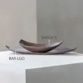 Dark brown serving dish with “BAR-LGO” and “BARGR-S” labels on a white platform against a light gray wall.
