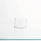 Cylindrical glass vase on white surface, transparent acrylic, reflective finish, simple form, flat base, open top, diffused lighting.