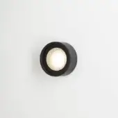 Wall-mounted light fixture, matte black metal, cylindrical design with frosted glass globe and warm light, studio product shot.