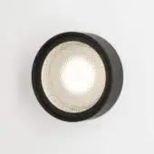 Circular wall light, matte black finish, with translucent inner surface featuring a repeating diamond-shaped, honeycomb texture.