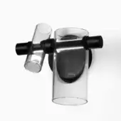Wall-mounted light fixture, transparent glass, asymmetrical design with two cylindrical shades and matte black metal rods attached to a circular plate.
