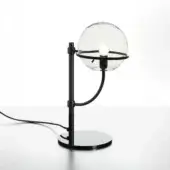 Black table lamp with spherical glass shade, black metal frame, curved arm, and circular base on gray surface against white backdrop.