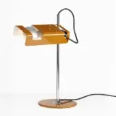 Mustard yellow desk lamp with chrome stem, circular base, pivoting arm, and curved metal shade directing light onto a white bulb.