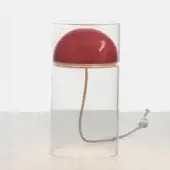 Table lamp, scarlet red, with clear glass cylindrical base and gold band, featuring copper cord and hemispherical acrylic shade.
