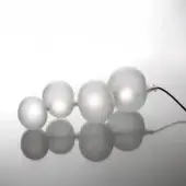 Frosted glass table with spherical elements and black cord, minimalist design, white glossy surface, diffused lighting, monochromatic palette.
