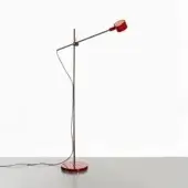 Scarlet red floor lamp with matte black metal stem, circular base, and cylindrical head, shown in a studio product shot.