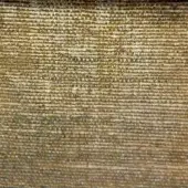 Woven textile with horizontal pattern in muted gold and charcoal, displaying a coarse texture and subtle sheen with visible yarn irregularities.