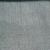 Woven textile sample, cool gray-green color, irregular grid pattern with heathered effect and visible square openings, studio shot.