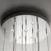 Circular chandelier with chrome canopy and mirrored lights, featuring clear crystal orbs suspended on silver cables, evenly spaced for a symmetrical design.