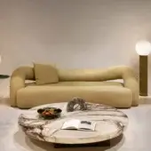 Distinguished Rugiano Abbraccio sofa with low curved form upholstered in warm beige fabric and bronzed brass details