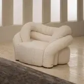 Lavish Rugiano Abbraccio lounge chair upholstered in creamy off-white fabric with elegant bronzed brass details