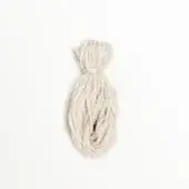 Natural wool cord, loosely coiled and knotted, against white; matte texture, elongated spiral form, variations in fiber tone, diffused lighting.