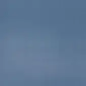 Muted blue-gray textured wall with subtle vertical striations and a faint horizontal line, exhibiting a sand-like, uneven surface quality.