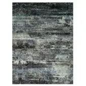 Rectangular Rugiano Flora rug, charcoal gray and blue abstract design, dense speckled texture resembling distressed stone, neutral gray background.