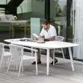 Sophisticated Varaschin Ellisse table with an elongated oval shape and smooth matte white HPL top crafted with powder coated aluminum