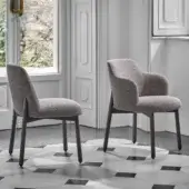 Distinguished Porada Abby chair with a gracefully curved Canaletto walnut frame and textured neutral gray upholstery in a satin finish