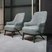 Sophisticated Zanaboni Kore lounge chair with muted gray textile upholstery and solid wooden base
