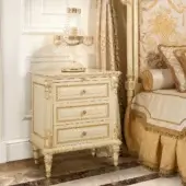 Distinguished Modenese Golden Radiance nightstand crafted with glossy wood and opulent gold detailing, showcasing carved floral motifs and curved legs
