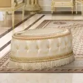 Lavish Modenese Golden Radiance oval ottoman crafted in cream and gold damask fabric with a subtly glossy finish and delicate fringe detailing