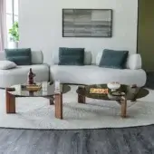 Premium Lagoon coffee table with walnut legs and bronze‑tone glass surface, subtle rippled texture casting dark smoky glow