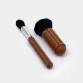 Exquisite Vèlle Milano cleaning brushes with brown leather handles, white stitching, black bristles and polished silver details