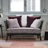 Refined Gervasoni Gray 05 loveseat in matte charcoal ash wood with slatted backrest and mauve cushions