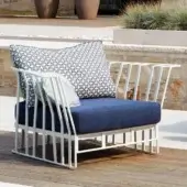 Sophisticated Roberti Rattan Hamptons Graphics lounge chair with navy blue and patterned textiles in a matte white powder-coated aluminum structure